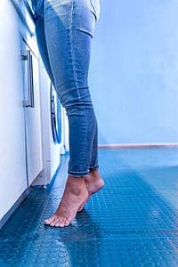 Feet of a woman standing on tiptoe at home in the kitchen